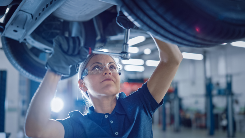 Female auto tech working on a car
