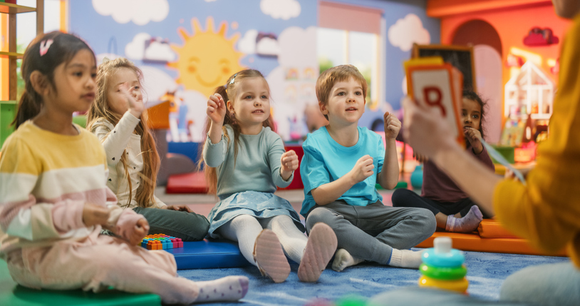 Elementary educator teaching young children their letters.