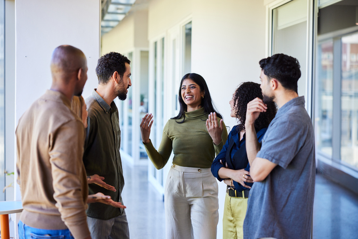 Business woman instructing worker in a hall meeting.