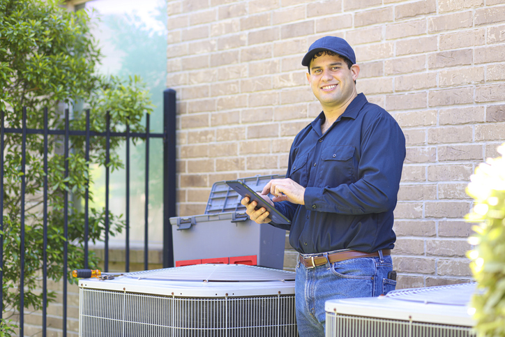 HVAC Technician repairing unit.