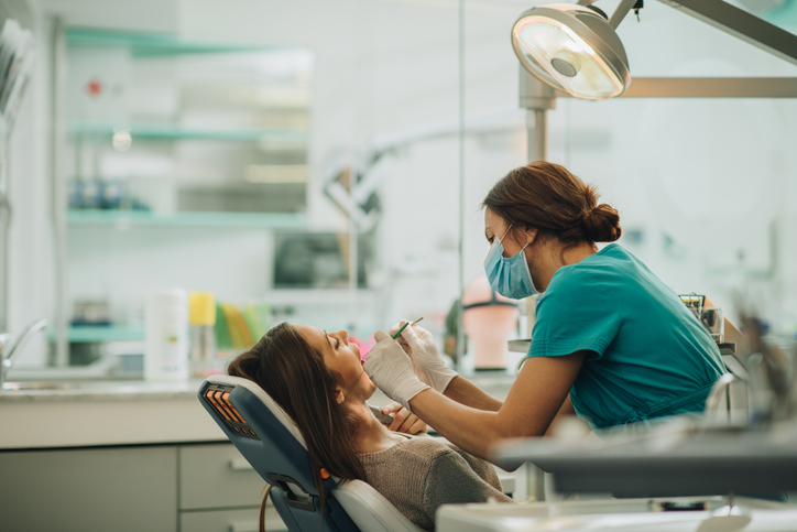 dental hygienist helping patient